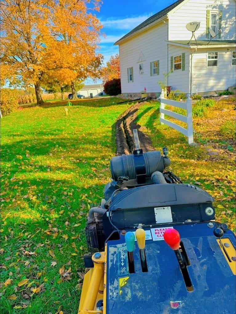 Trencher cutting underground service trench for residential electrical